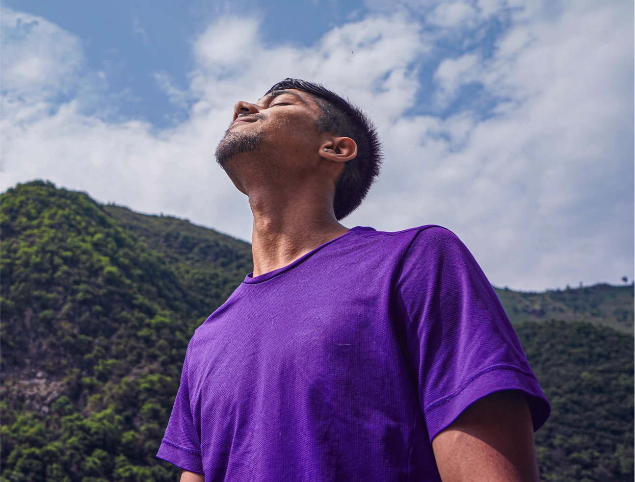 Homem ao ar livre respirando profundamente e sorrindo, simbolizando liberdade, inovação e novas possibilidades
